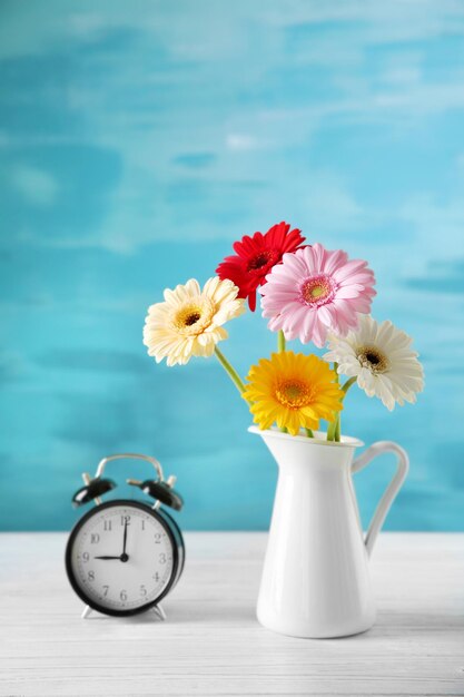 Vase with bouquet of beautiful flowers on color background