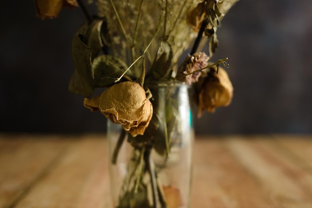 Vase with dried flowers on wooden table