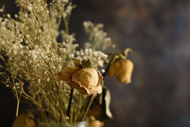 Vase with dried flowers on wooden table