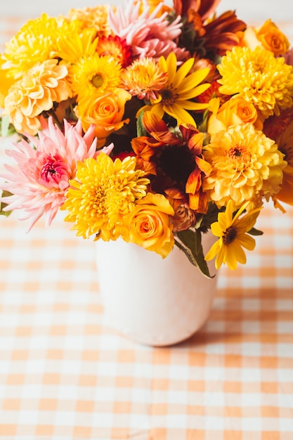 Vase with flowers on the table in a kitchen