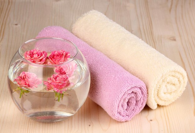 Vase with roses spa setting on wooden background