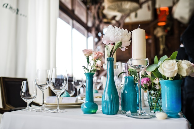 Vase with white roses on the table in the restaurant