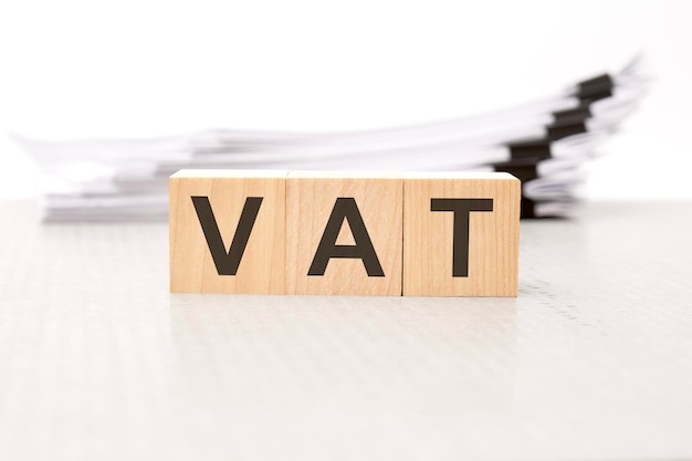 Vat letters on wooden cubes the background is a white business papers finance concept