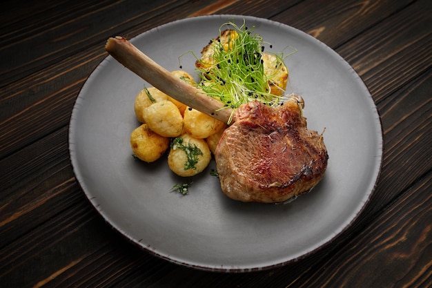 Veal entrecote with potatoes and corn on a wooden background