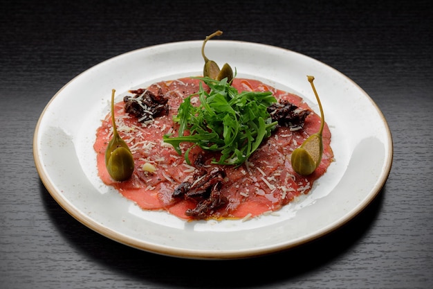 Veal fillet carpaccio with arugula and capers