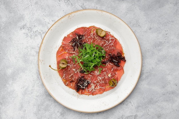 Veal fillet carpaccio with arugula and capers