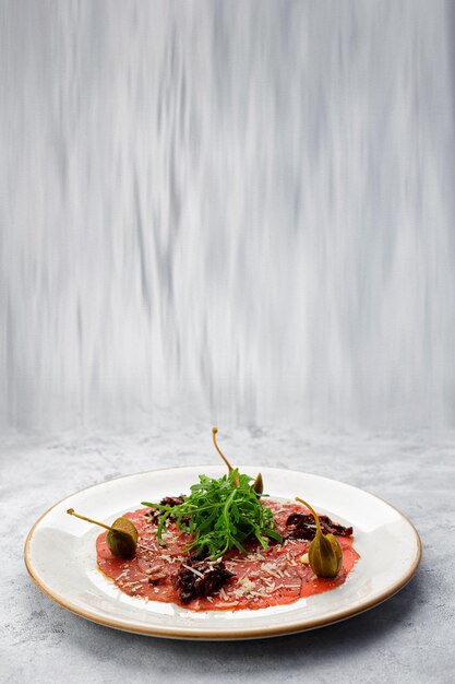 Veal fillet carpaccio with arugula and capers