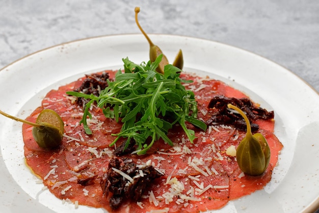 Veal fillet carpaccio with arugula and capers