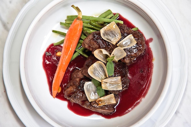 Veal medallions in raspberry sauce with roasted onion and carrot food gastronomy meat