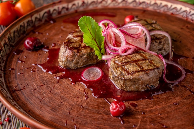 Veal medallions with cherry sauce served with pickled onions and radishes a gourmet dish Horizontal orientation