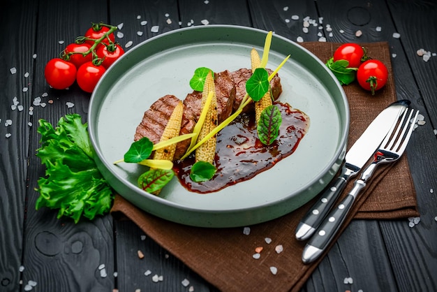 Veal medallions with veal with berry sauce and baby corn