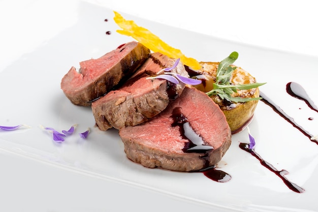 Veal medallions with wine sauce on white background