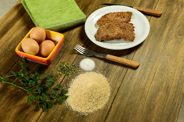 Veal milanese presented on the table with ingredients