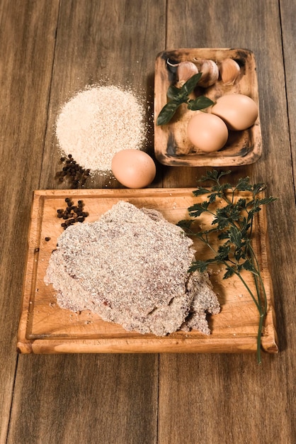 Veal milanese presented on the table with ingredients