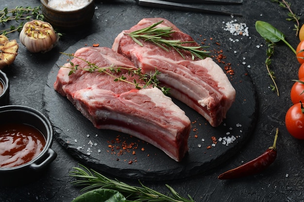 Veal Raw veal steak on the bone on a black stone background Meat