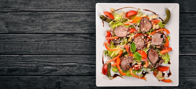 Veal Salad Lettuce and Fresh Vegetables on the plate On a wooden background Top view Free space for text