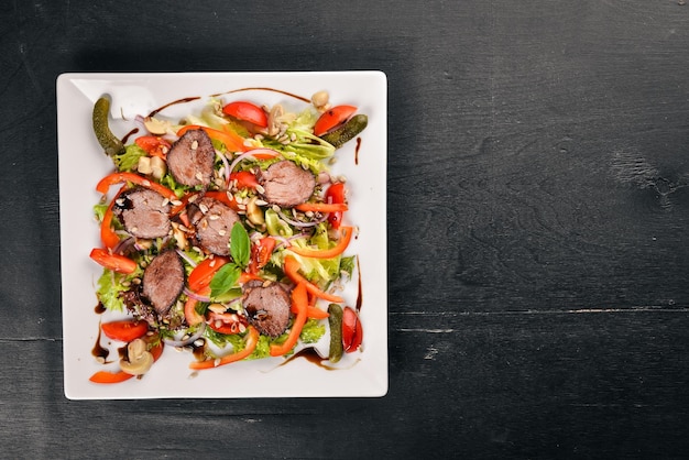 Veal Salad Lettuce and Fresh Vegetables on the plate On a wooden background Top view Free space for text