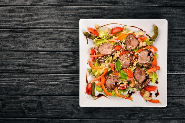 Veal Salad Lettuce and Fresh Vegetables on the plate On a wooden background Top view Free space for text