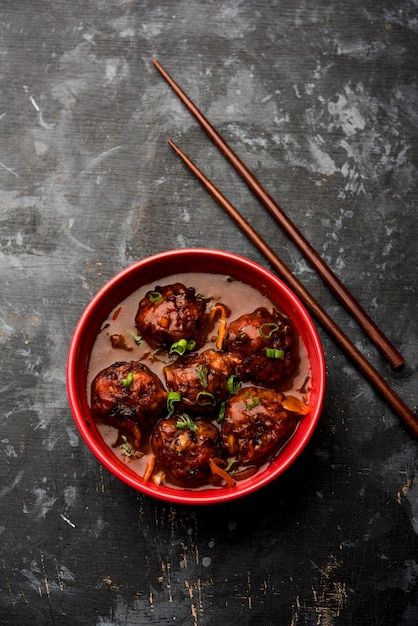 Veg or chicken Manchurian with gravy - Popular food of India served in a bowl with chopstick