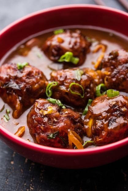 Veg or chicken Manchurian with gravy - Popular food of India served in a bowl with chopstick