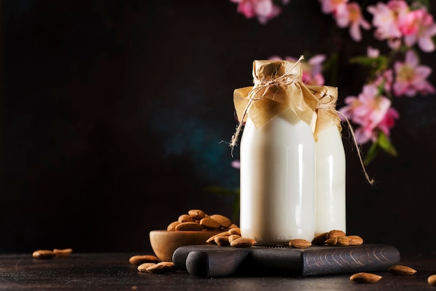 Vegan almond milk in bottles closeup brown background Non dairy alternative milk Healthy vegetarian food and drink concept Copy space