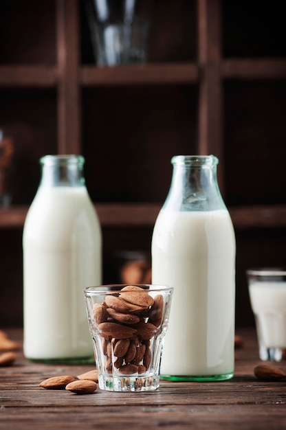 Photo vegan almond milk on the wooden table, selective focus