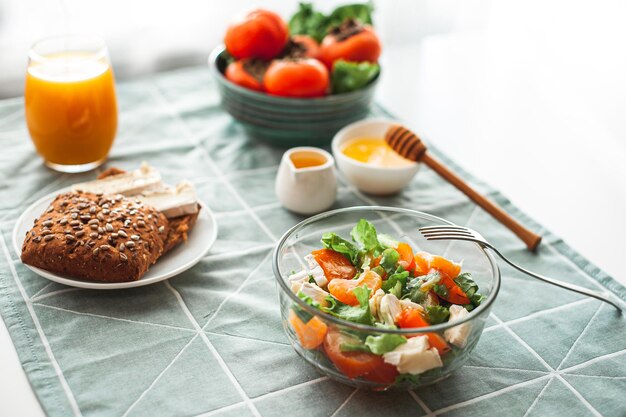 Vegan breakfast or lunch light sweet and sour salad with persimmon tangerines and cheese winter