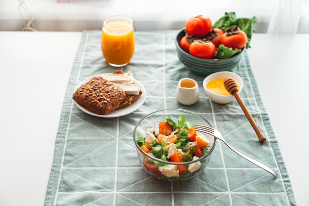 Vegan breakfast or lunch light sweet and sour salad with persimmon tangerines and cheese winter