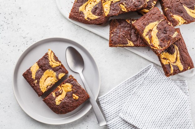 Vegan brownie with peanut butter on white background, top view.