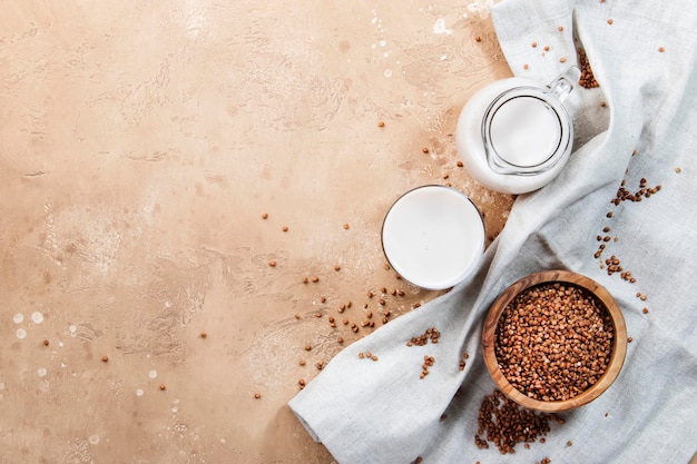 Vegan Buckwheat plant based milk in bottles closeup brown background Non dairy alternative milk Healthy vegetarian food and drink concept Copy space top view