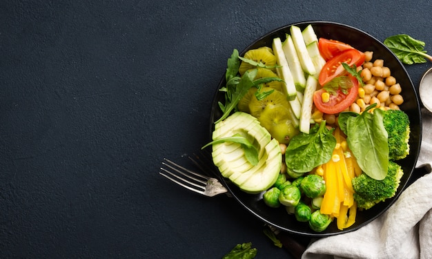 Vegan buddha bowl. Healthy food nutritionist concept. Healthy vegetarian vegetable lunch of chickpeas, broccoli, pepper, tomato, spinach, arugula and avocado. Top view