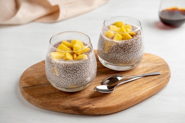 Vegan chia coconut pudding with mango on white background. Healthy nutrition, superfood. Closeup view.