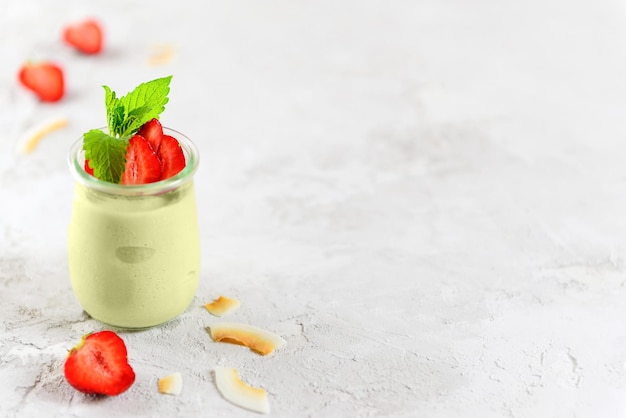 Vegan dessert panna cotta with avocado fresh strawberries and mint