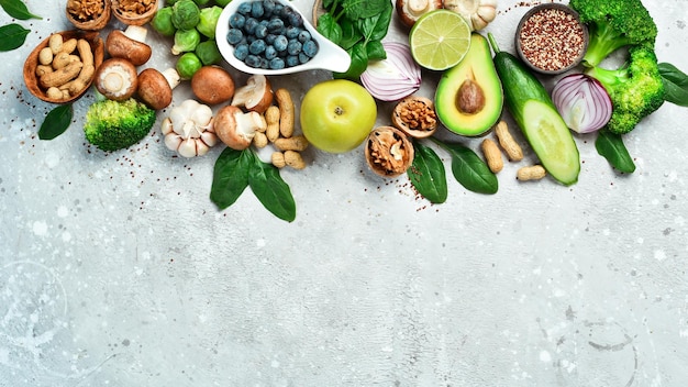 Vegan diet with a high content of dietary fiber and strengthens the immune system fresh vegetables fruits nuts mushrooms and berries On a gray stone background Top view