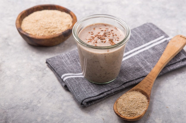 Vegan non dairy drink, with oat bran on white concrete background. Healthy eating