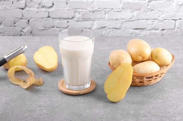 Vegan potato milk and potato on grey stone table background plant based alternative milk replacer