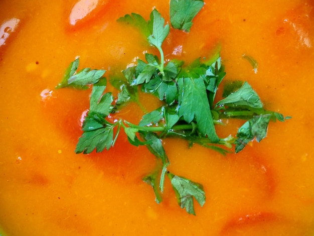 Vegan pumpkin soup with tomatoes and fresh herbs