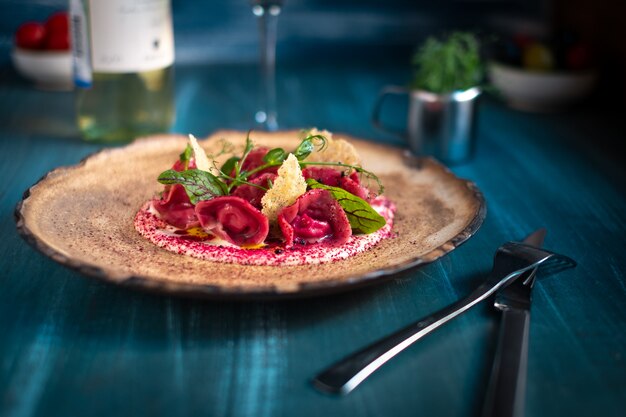 Vegan red ravioli with beetroot on a plate in cream sauce