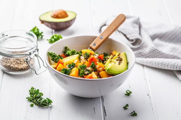 Vegan salad with rice, kale, baked pumpkin, carrots and avocado