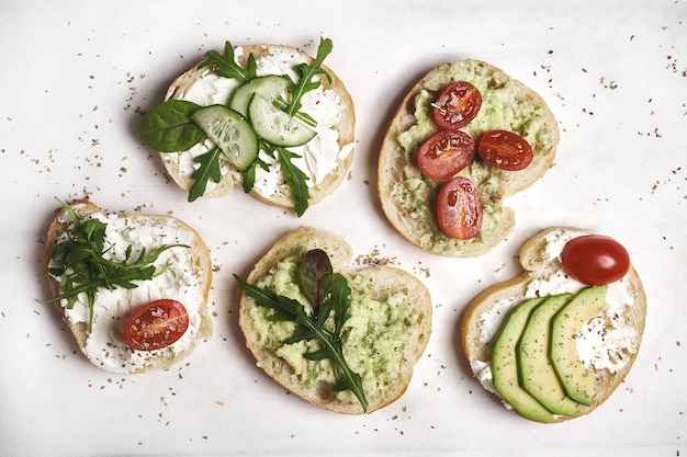 Vegan sandwiches with curd cheese and vegetables on wooden background.