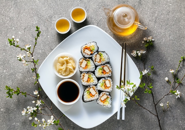 Vegan sushi with tofu in General Tso sauce, avocado and fresh vegetables