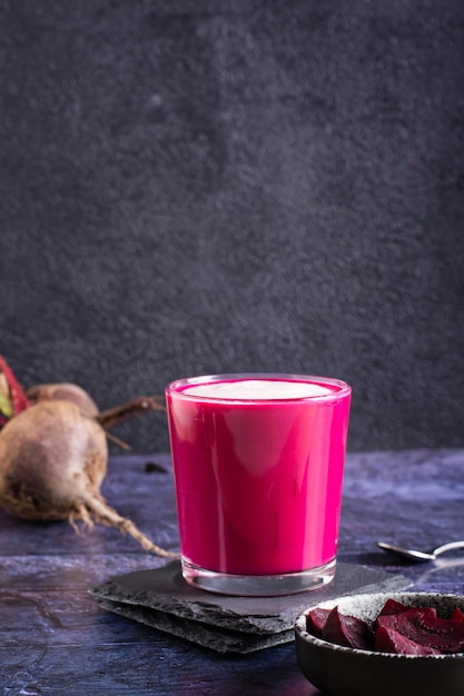 Vegetable beetroot latte in a glasss on the table Coffee alternative Vertical view