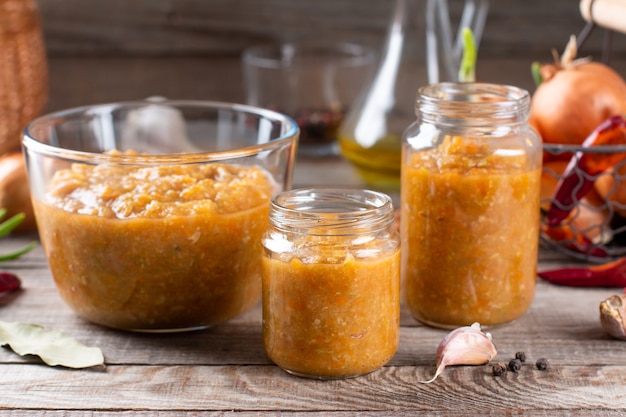 Vegetable caviar in a glass jar on a wooden background