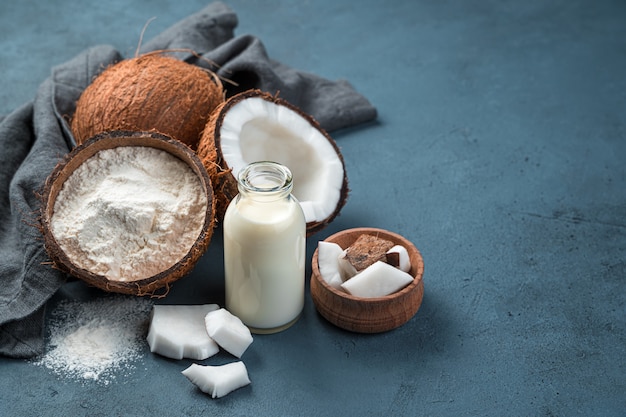 Vegetable coconut milk and gluten-free flour. Healthy organic products. Milk and coconut flour on a dark background. Copy space.