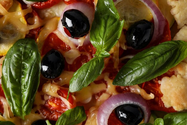 Vegetable galette with olives and basil top view