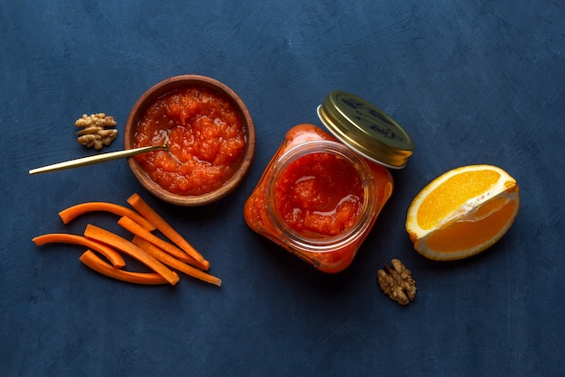 Vegetable jam with carrots and orange on a dark background