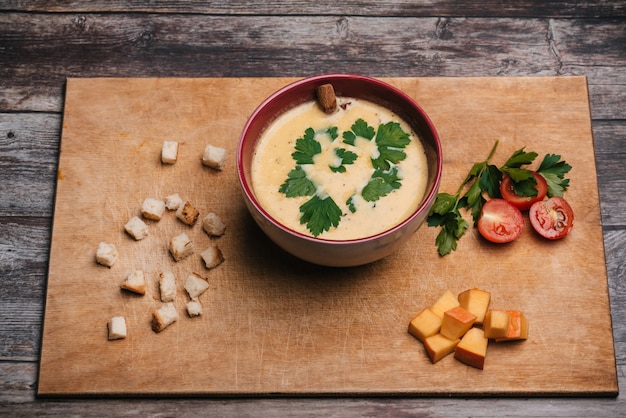 Vegetable pumpkin cream soup in a plate on a cutting Board with parsley