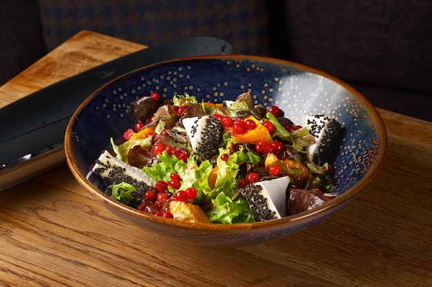 Vegetable salad of cabbage with walnuts and cheese on the table, serving in a restaurant, menu food concept.