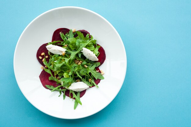 Vegetable salad of fresh beets, arugula, cottage cheese, pine nuts