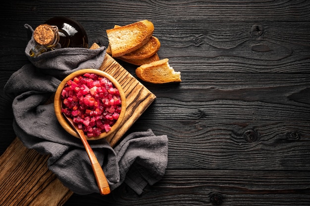 Vegetable salad and toasted bread on wooden background top view, copy space